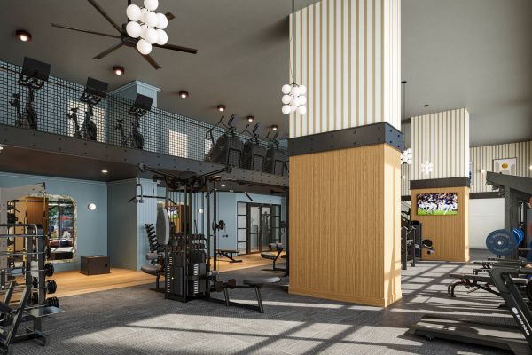 Modern gym with various workout machines, weights, a mezzanine level, and a TV on the wall showing sports.