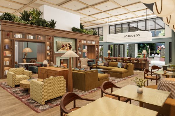Modern lounge with cozy seating, bookshelves, warm lighting, and a "GO HOOS GO" sign overhead.