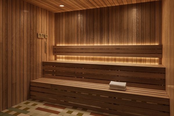 Modern wooden sauna with built-in bench seating, soft lighting, and a white towel placed on the bench.